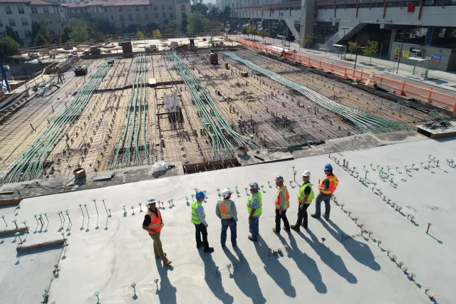 İnşaat şantiyesinde temel alanını inceleyen baretli ekip